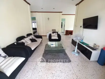Spacious living room with modern furniture and wall-mounted TV
