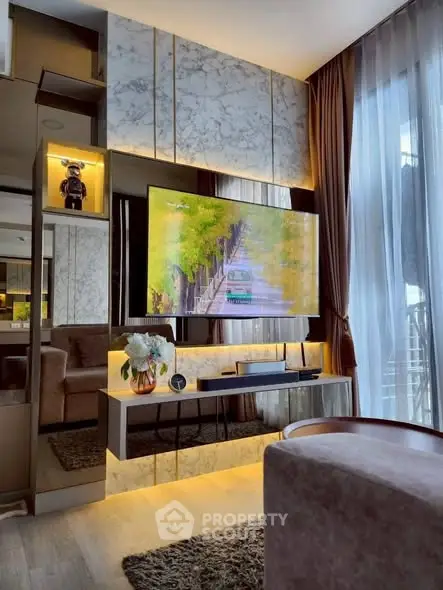 Luxurious living room with modern decor and large TV, featuring elegant lighting and plush seating.