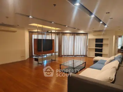 Spacious modern living room with sleek wooden flooring and large windows