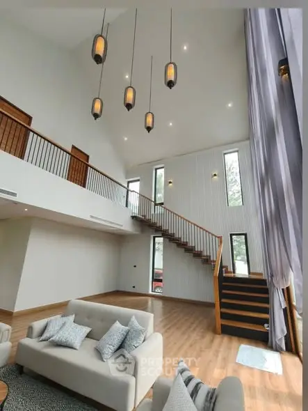 Spacious modern living room with high ceilings and elegant staircase