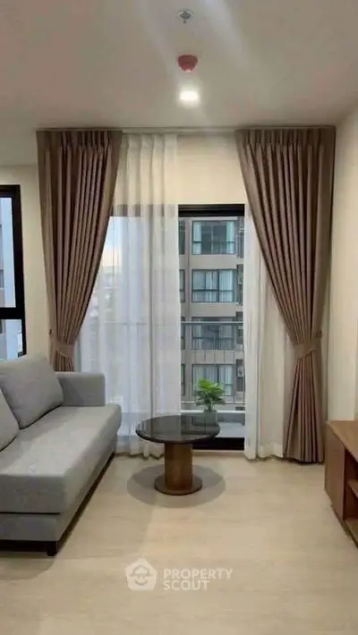 Modern living room with large window and elegant curtains in a high-rise apartment.