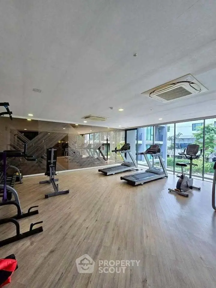 Modern gym with state-of-the-art equipment and large windows for natural light.