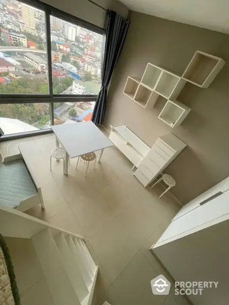 High-rise apartment living room with modern minimalist furniture and a large window offering an urban view, perfect for young professionals.