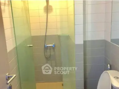 Modern bathroom with glass shower enclosure and sleek tile design.