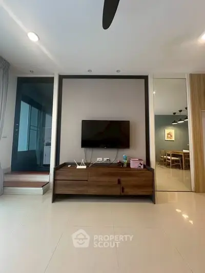 Modern living room with sleek TV setup and stylish dining area