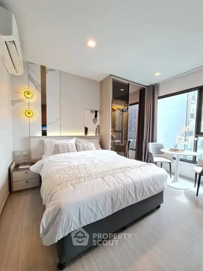 Modern bedroom with stylish decor and large windows offering city views, perfect for urban living.