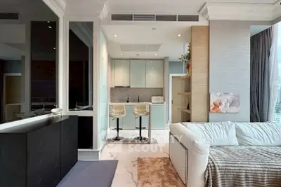 Modern open-plan living room with sleek kitchen and cozy seating area in luxury apartment.