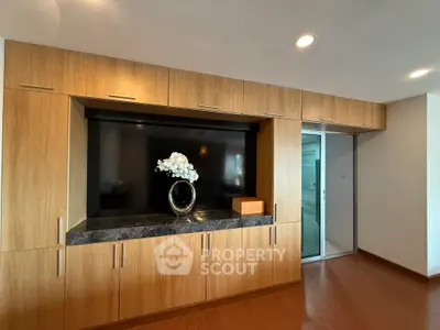 Modern living room with sleek wooden cabinetry and elegant decor