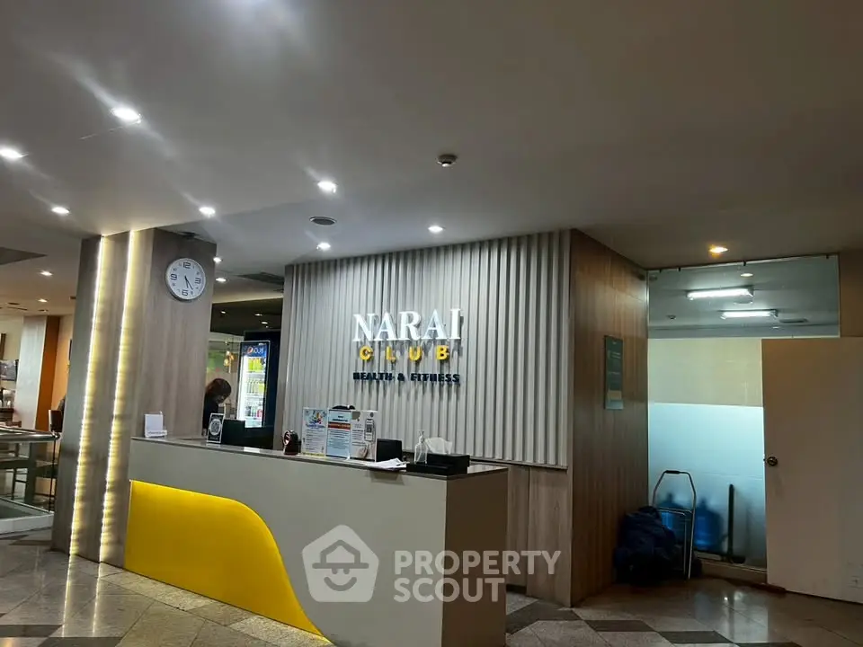 Modern gym entrance with sleek reception desk and stylish lighting, inviting fitness enthusiasts.