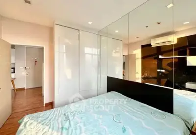 Modern bedroom with mirrored wall and built-in wardrobe in a stylish apartment.