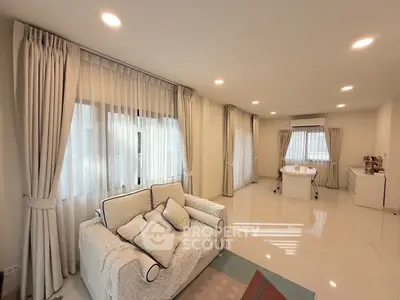 Spacious living room with elegant white decor and natural light