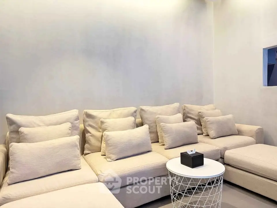 Cozy living room with plush beige sectional sofa and modern round table.