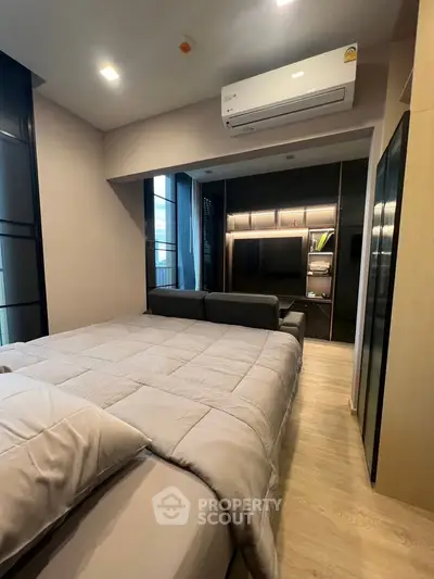Modern bedroom with cozy bed, sleek air conditioning, and stylish built-in storage in a contemporary apartment.