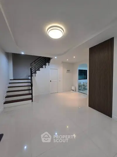 Spacious modern living room with sleek staircase and elegant lighting