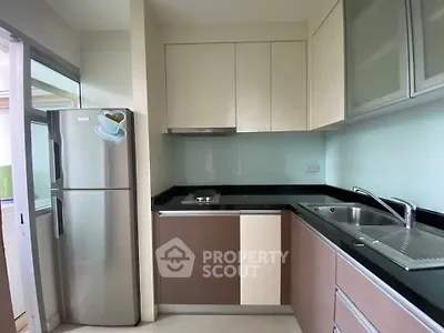 Modern kitchen with sleek cabinetry and stainless steel appliances in a compact layout.