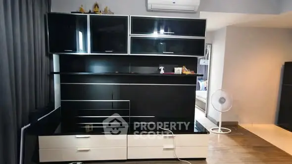 Modern living room with sleek black and white entertainment unit and air conditioning.