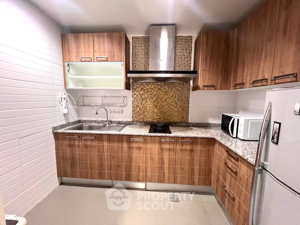 Modern kitchen with wooden cabinets, granite countertops, and stainless steel appliances