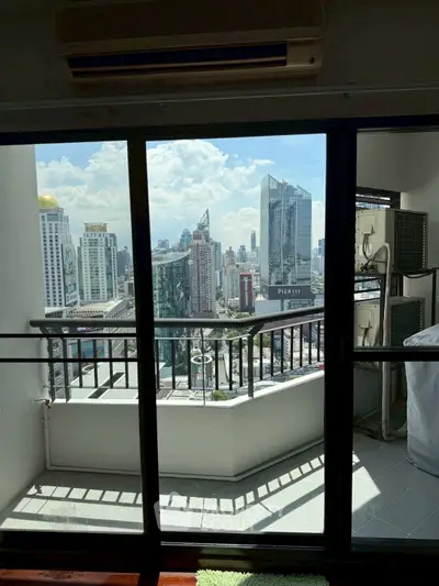 Stunning city view from modern balcony with glass doors in high-rise apartment.