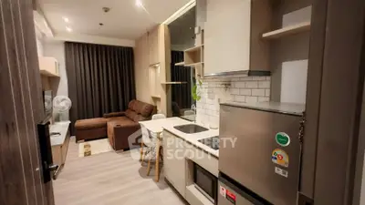 Modern open-layout kitchen and living room with sleek design and cozy seating area.