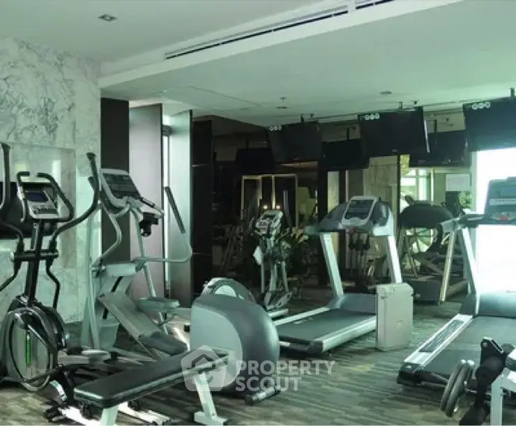 Modern gym with state-of-the-art fitness equipment in luxury residential building.