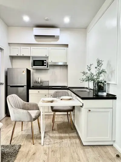 Modern kitchen with sleek appliances and elegant dining setup in a cozy apartment.