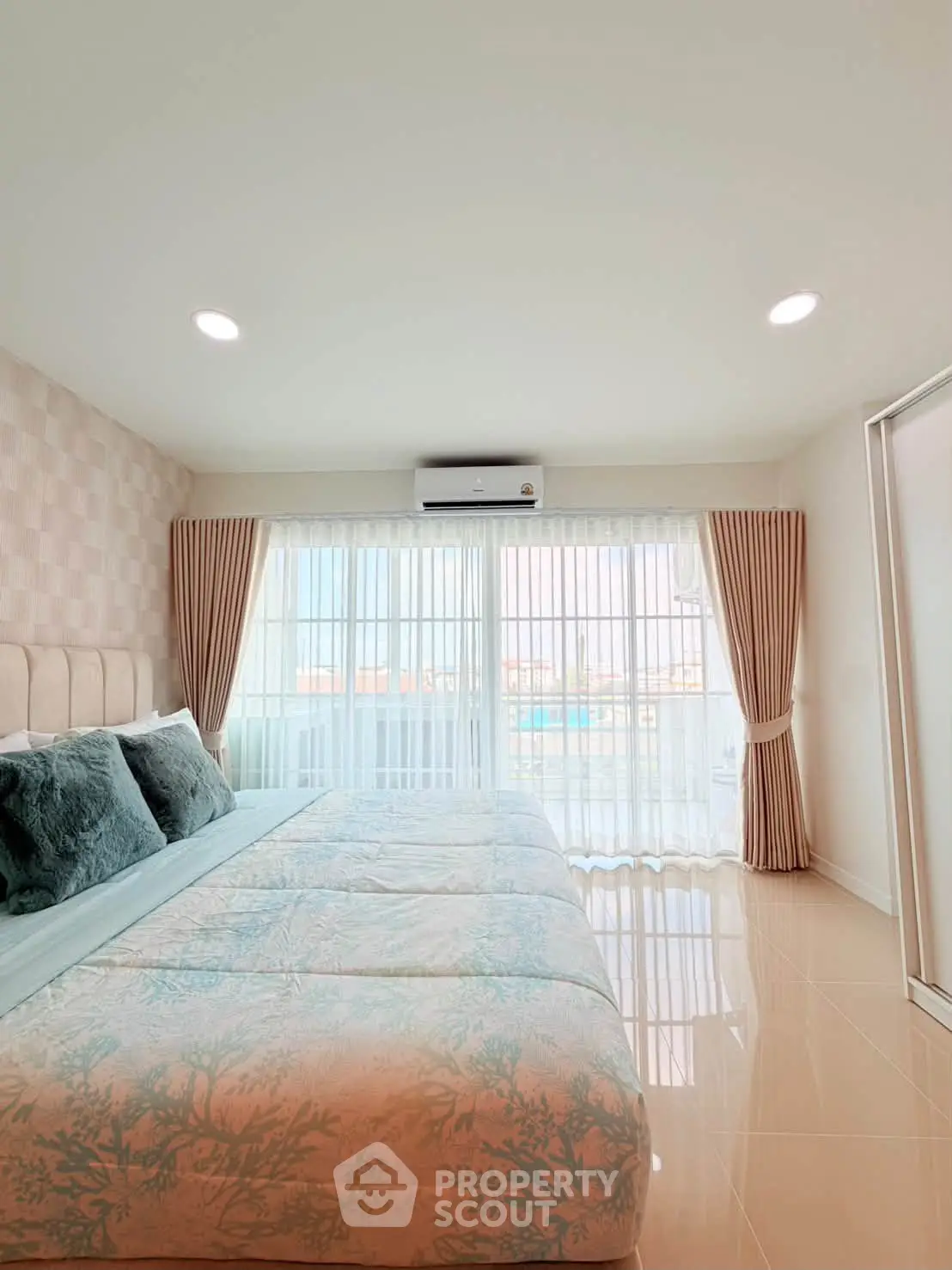 Spacious bedroom with large windows and elegant decor in modern apartment