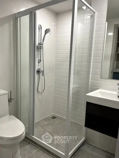 Modern bathroom with glass shower enclosure and sleek fixtures.