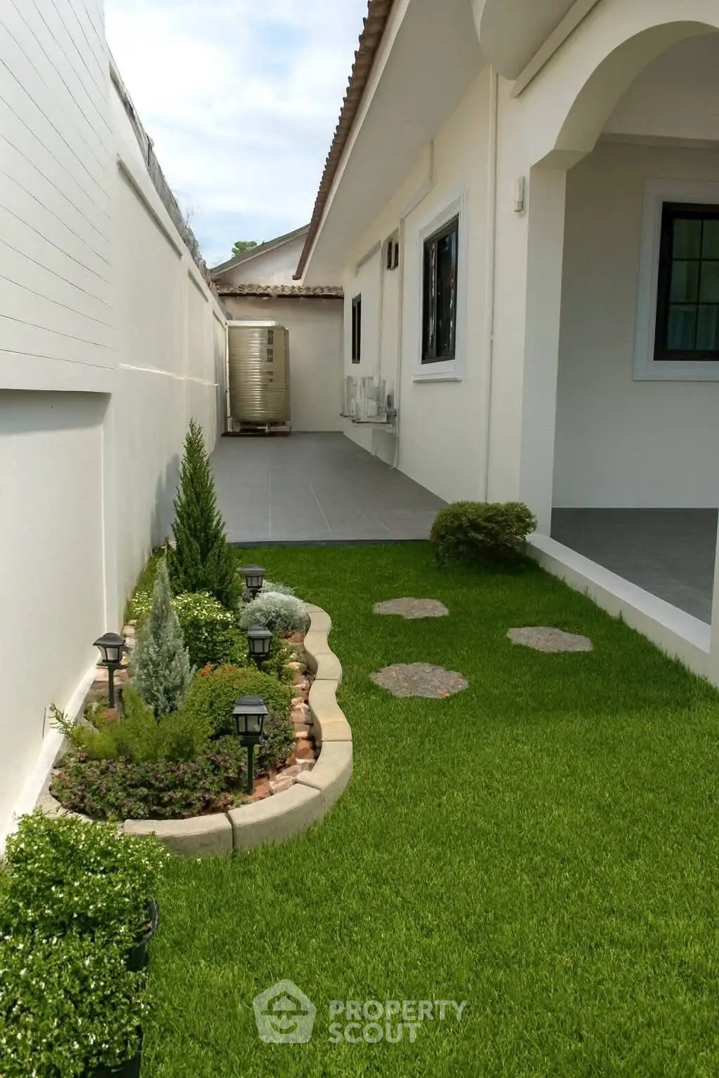Charming garden with lush greenery and modern exterior design in a serene residential setting.