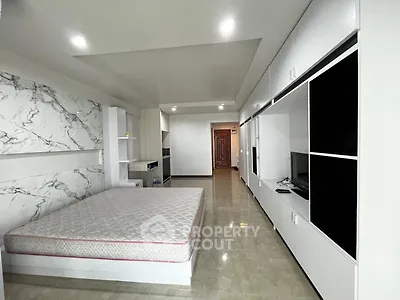 Spacious modern bedroom with marble accents and built-in storage