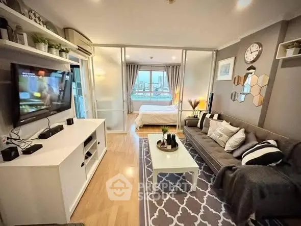 Modern living room with stylish decor and open view to bedroom, featuring sleek furniture and ambient lighting.
