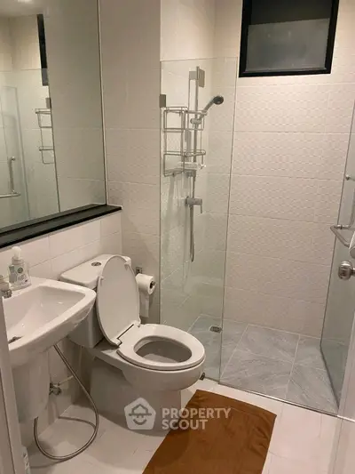 Modern bathroom with glass shower and sleek fixtures in a contemporary home.