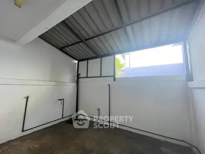 Spacious storage area with high ceiling and natural light