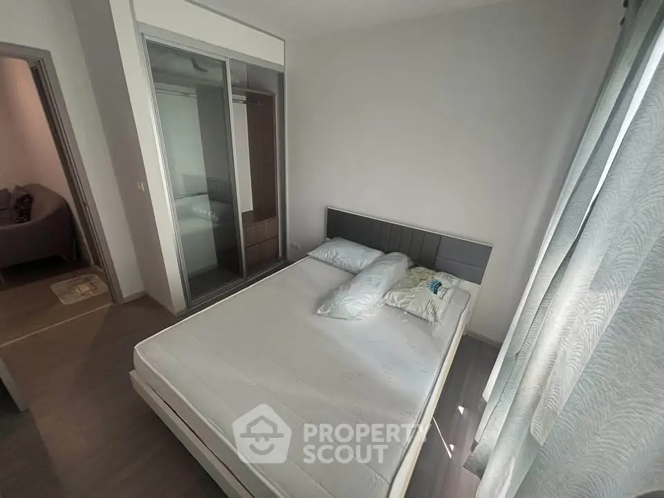 Spacious bedroom with modern design and ample natural light, featuring a comfortable bed and sleek wardrobe.