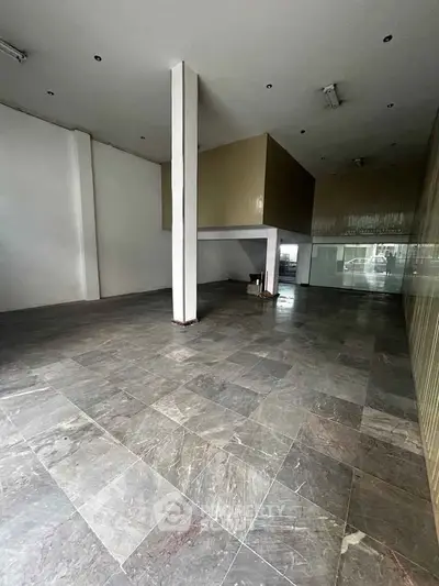 Spacious modern interior with sleek tiled flooring and high ceilings, ideal for versatile use.