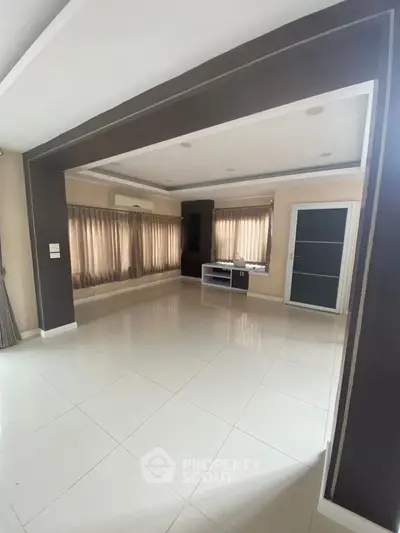 Spacious modern living room with large windows and elegant ceiling design