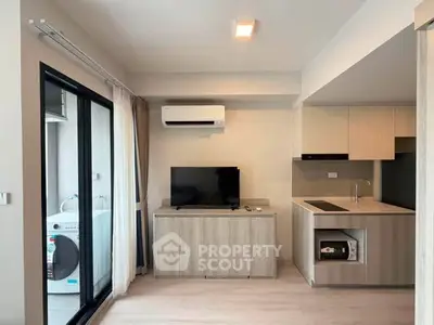 Modern living room with kitchen and balcony, featuring air conditioning and washing machine.