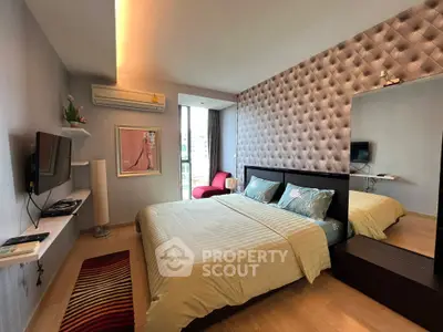 Modern bedroom with stylish decor and natural light, featuring a cozy bed and wall-mounted TV.