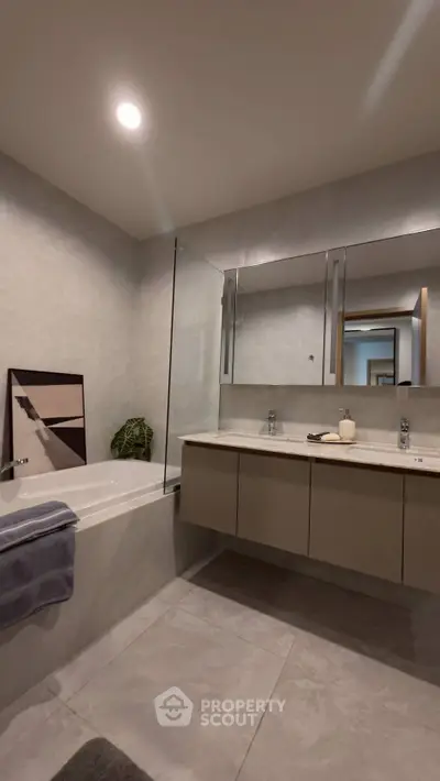 Modern bathroom with sleek design, featuring a bathtub and elegant fixtures.