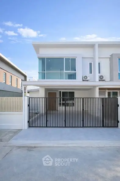 Modern two-story townhouse with sleek design and gated entrance