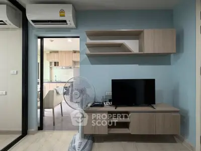 Modern living room with wall-mounted shelves and TV, open layout to kitchen