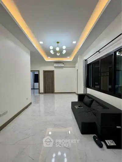 Spacious modern living room with sleek black sofa and elegant lighting