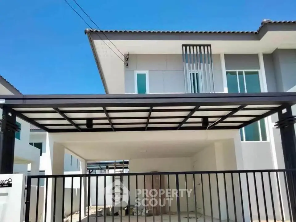 Modern two-story house with sleek carport and gated entrance, showcasing contemporary architecture.