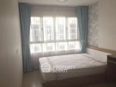 Cozy bedroom with large window and soft curtains, perfect for natural light lovers.