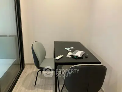 Modern minimalist study room with sleek black table and two chairs, perfect for focused work.