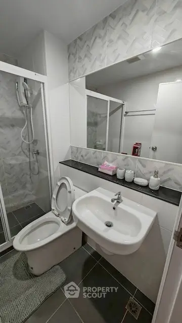 Modern bathroom with sleek shower and stylish sink in contemporary apartment.