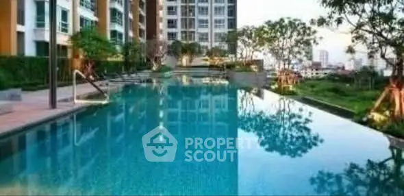 Luxurious apartment complex with stunning outdoor pool and lush greenery.