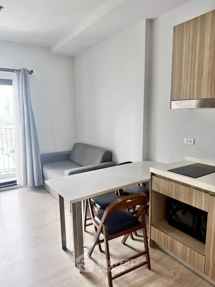 Modern living room with sleek furniture and open kitchen layout in a bright apartment.