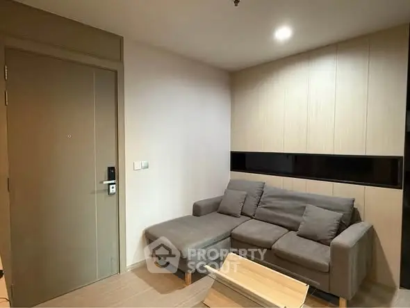 Modern living room with cozy gray sofa and wooden accents, perfect for relaxation and comfort.