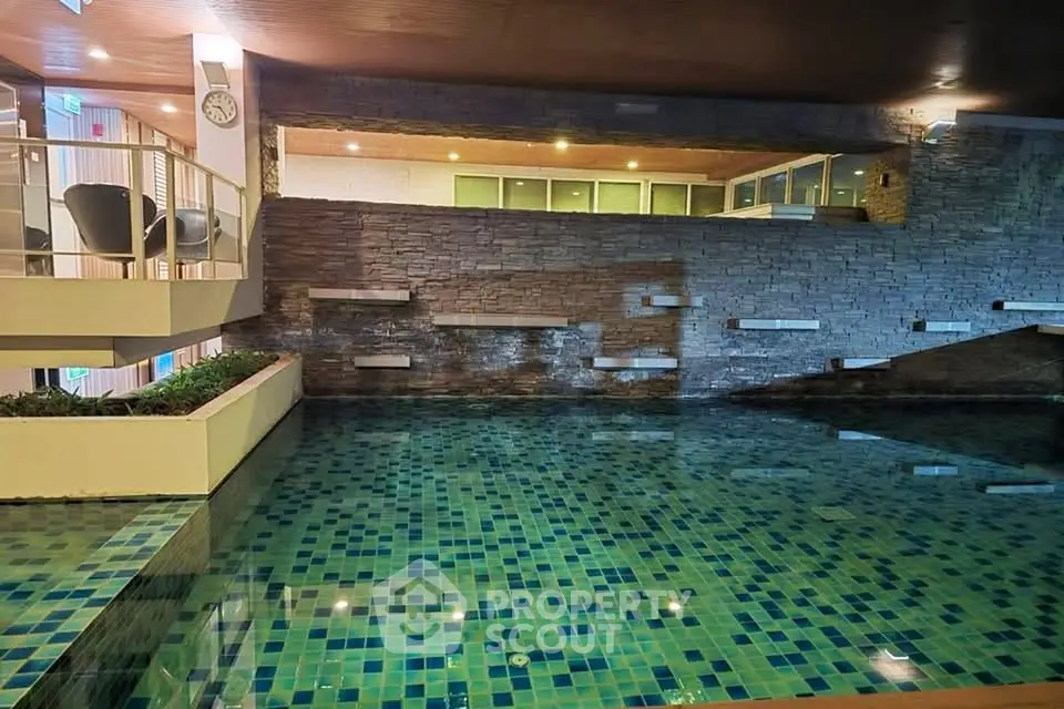 Luxurious indoor pool with modern design and ambient lighting in upscale residential building.