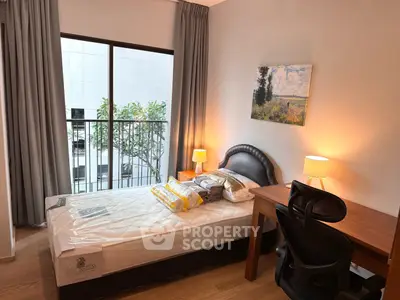 Cozy bedroom with modern furnishings and a view of the cityscape, perfect for urban living.